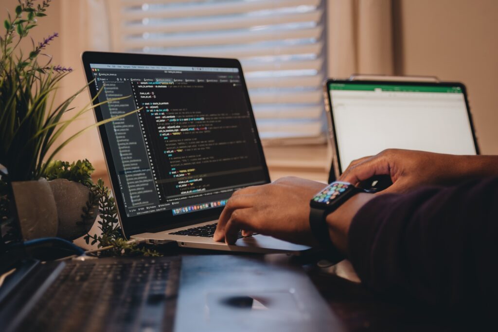 African American man sitting in front of computer coding, programming, web developer