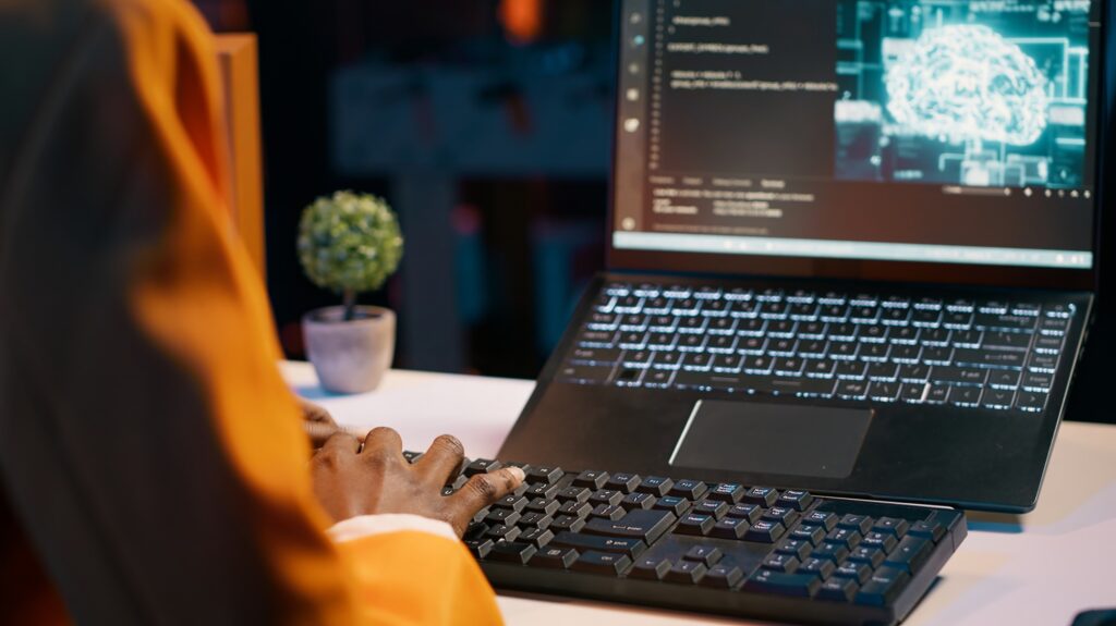 IT student works with artificial intelligence brain system on laptop